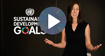 An image of a video thumbnail for the UNGC & Brambles video. The image consisting of a capture of the video with a middle age lady speaking beside the 'Sustainability Development Goals' logo on a dark background. This content is underlaid behind a play button icon.