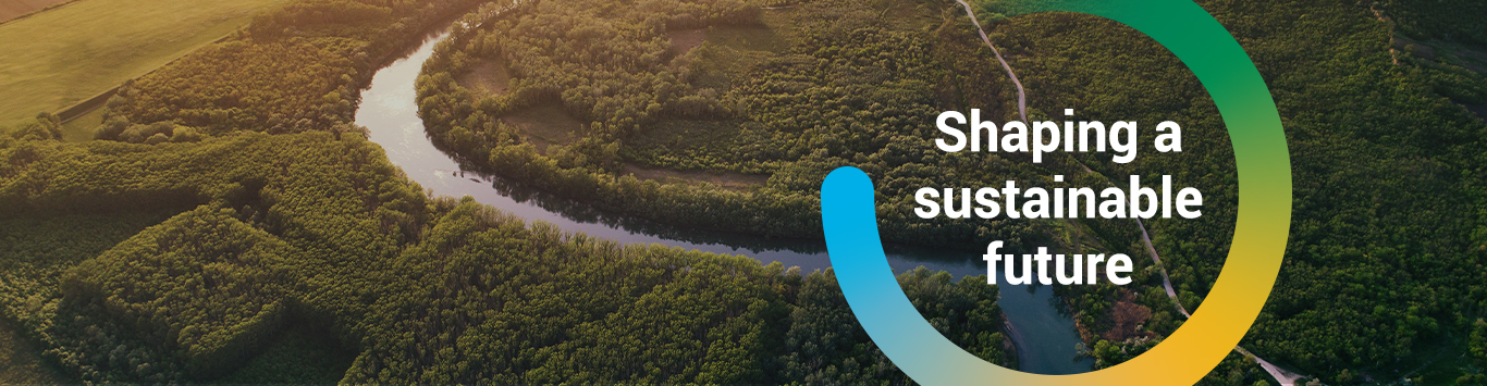 An aerial photograph of a river with the words Shaping a Sustainable Future inside a colourful circle