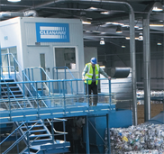 A photograph of a Cleanway employee in fluorescent workwear overlooking a factory