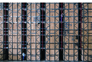 A long shot of a worker in front of shelves of stock in a warehouse